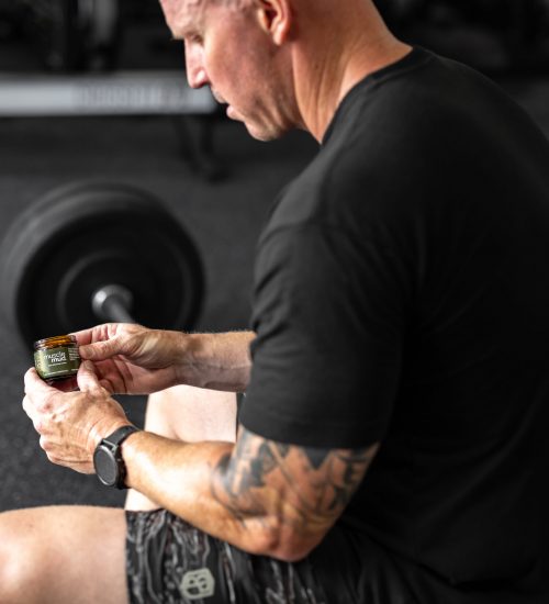 lyman-using-mud-at-gym Weightlifter using musclemud natural pain relief cream for weightlifting pain.